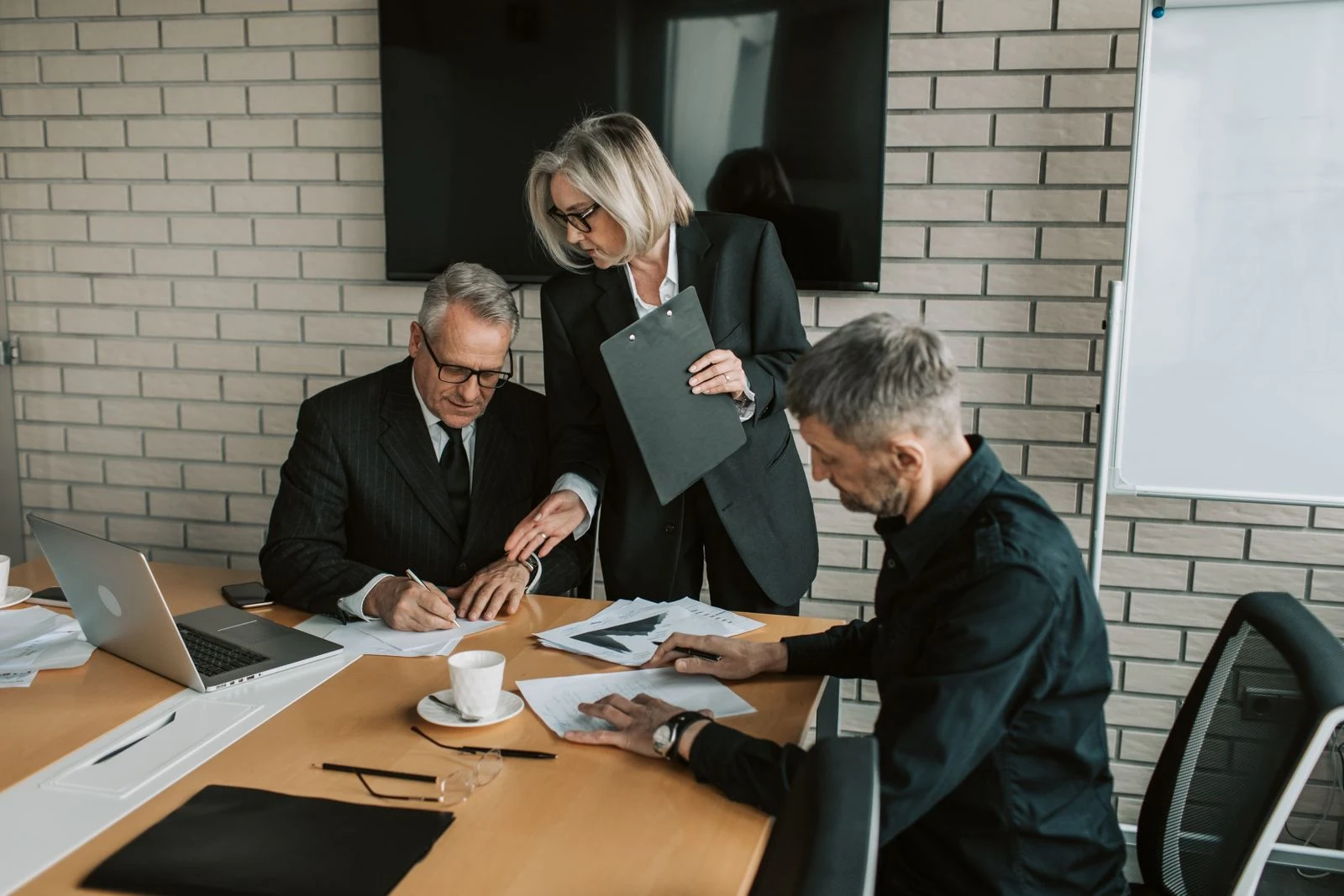 Three experienced professionals working through business documents together